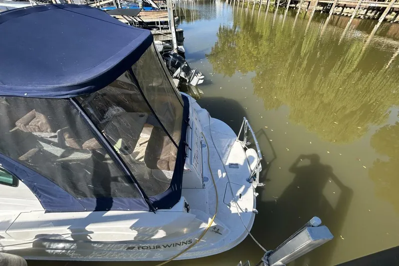  Yacht Photos Pics 2011 Four Winns V335 boat docked on calm water with blue canopy.