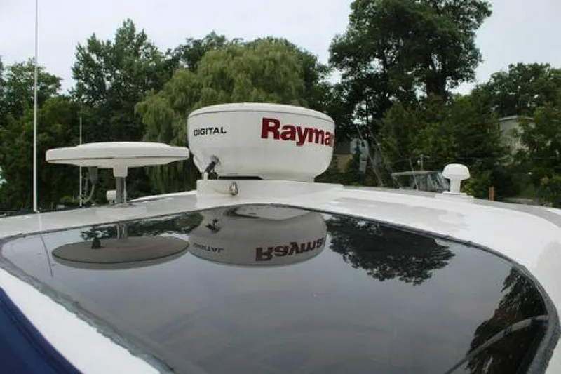  Yacht Photos Pics 2011 Four Winns V335 boat with Raymarine radar on deck, surrounded by trees.