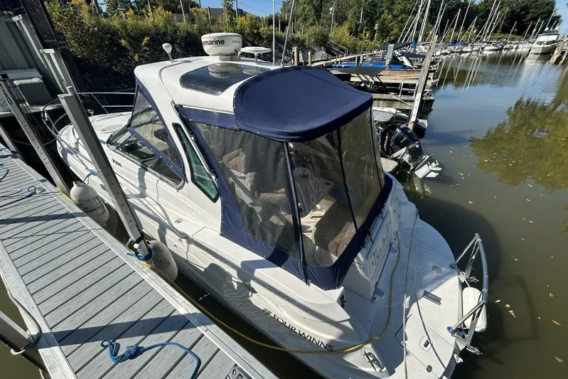  Yacht Photos Pics 2011 Four Winns V335 boat docked at marina, featuring blue canopy and sleek design.