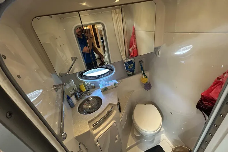  Yacht Photos Pics 2011 Four Winns V335 boat bathroom with sink, toilet, mirror, and porthole window.