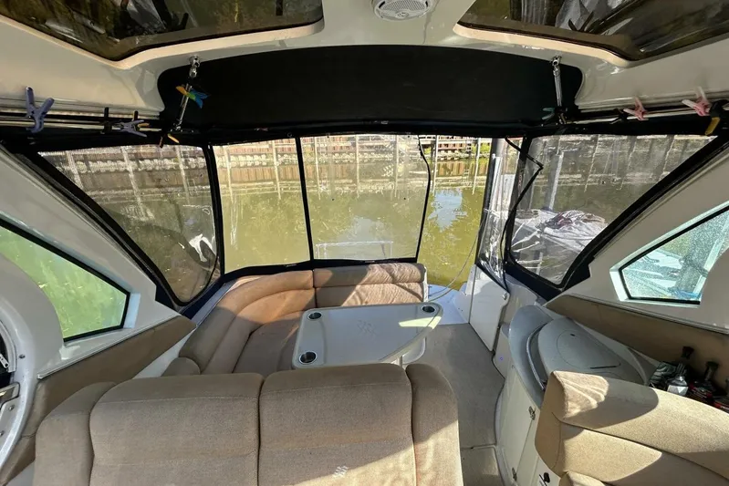  Yacht Photos Pics Interior of 2011 Four Winns V335 boat with seating and table, docked by water.