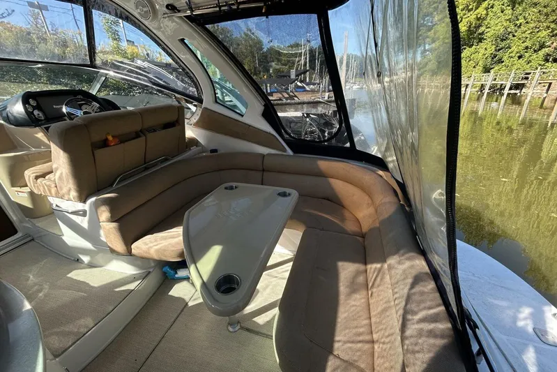  Yacht Photos Pics Interior of 2011 Four Winns V335 boat with beige seating and table, docked by water.