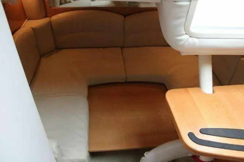  Yacht Photos Pics Cozy interior of 2011 Four Winns V335 boat with cushioned seating and wooden table.