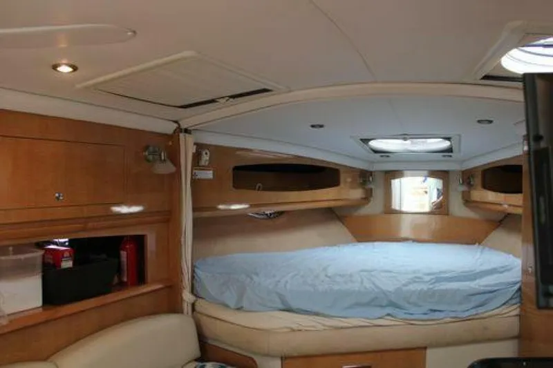  Yacht Photos Pics 2011 Four Winns V335 cabin interior with bed, wooden cabinetry, and ceiling lights.