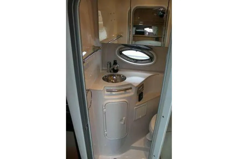 Yacht Photos Pics 2011 Four Winns V335 boat bathroom with sink, mirror, and porthole window.