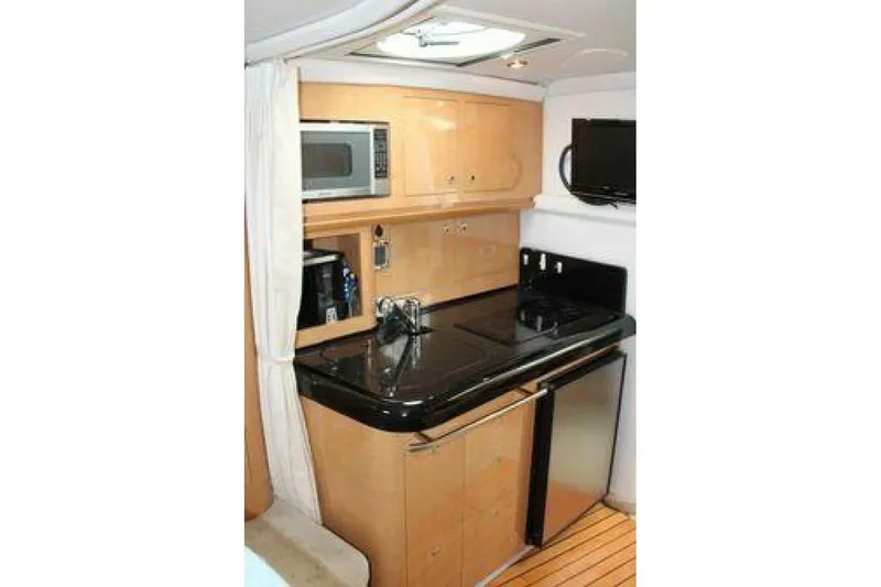  Yacht Photos Pics 2011 Four Winns V335 yacht kitchen with microwave, stove, and compact fridge.