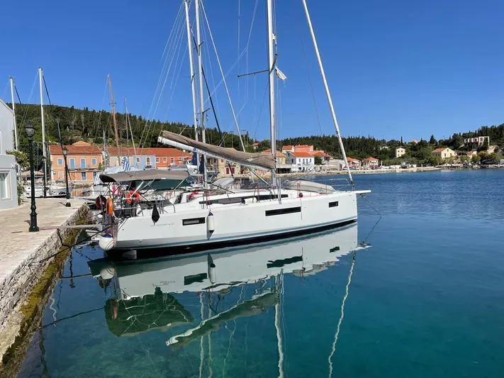  Yacht Photos Pics 2020 Jeanneau Sun Odyssey 410 sailboat docked in a scenic harbor.