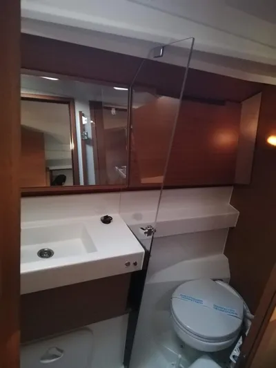  Yacht Photos Pics 2020 Jeanneau Sun Odyssey 410 bathroom with modern fixtures and wooden accents.