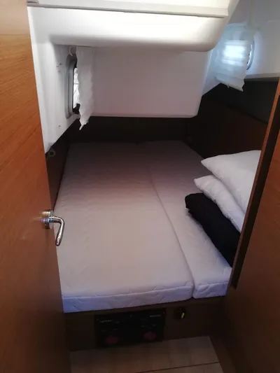  Yacht Photos Pics Cozy cabin interior of 2020 Jeanneau Sun Odyssey 410 sailboat with bed and pillows.