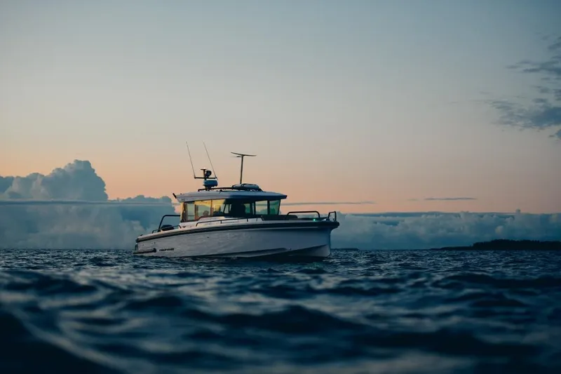  Yacht Photos Pics 2025 Axopar 37XC CROSS CABIN BRABUS Trim boat on calm water at sunset.