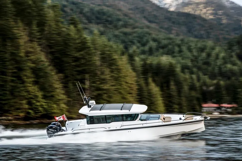 Yacht Photos Pics 2025 Axopar 37XC CROSS CABIN BRABUS Trim cruising on a scenic forest-lined waterway.