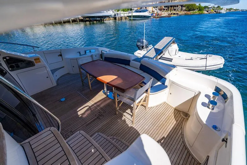 All In Yacht Photos Pics Luxurious 2010 Azimut 62 Evolution Fly yacht deck with seating and table, overlooking serene waters.