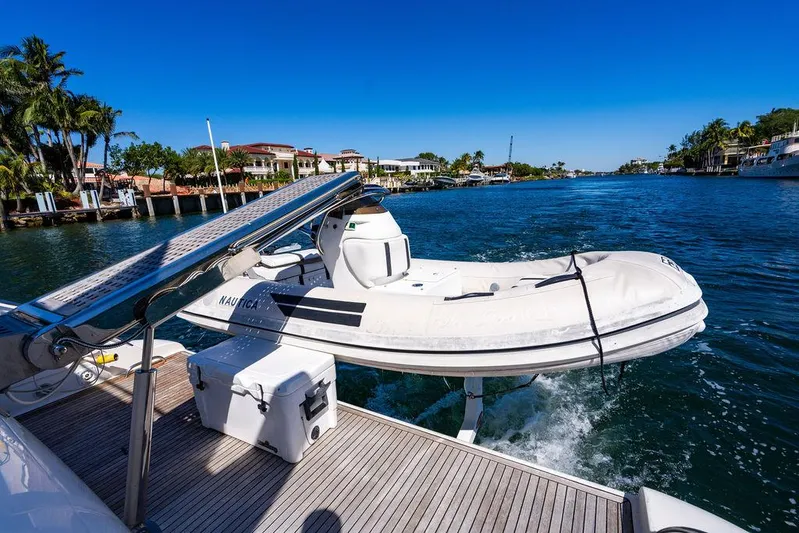 All In Yacht Photos Pics Azimut 62 Evolution Fly yacht with tender on deck, cruising in sunny waterfront setting.