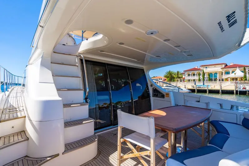 All In Yacht Photos Pics 2010 Azimut 62 Evolution Fly yacht deck with seating and table, overlooking waterfront homes.