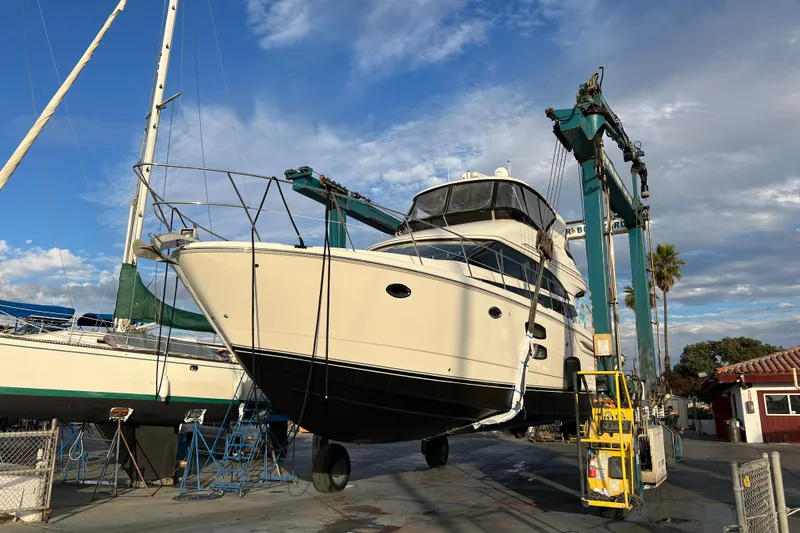  Yacht Photos Pics 2013 Meridian 441 Sedan yacht lifted in a boatyard under a blue sky.