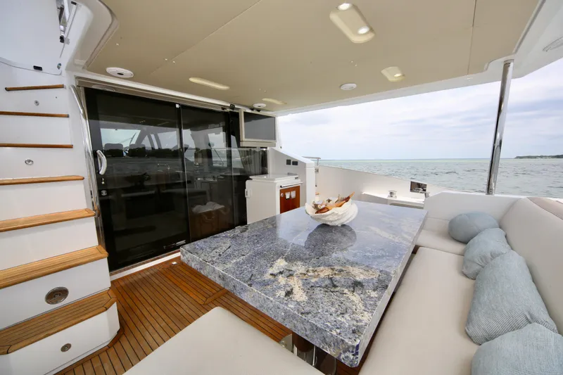 Kiki Yacht Photos Pics Luxurious Azimut 66 yacht interior with elegant dining area, marble table, and ocean view.