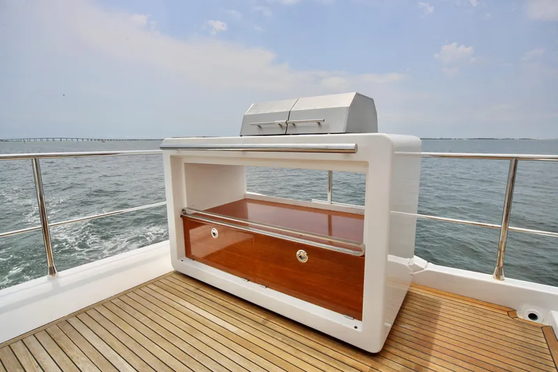 Kiki Yacht Photos Pics Luxury yacht Azimut 66 (2016) deck with built-in grill, overlooking the ocean.