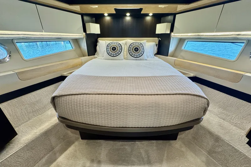 Kiki Yacht Photos Pics Luxurious bedroom interior of 2016 Azimut 66 yacht with elegant bedding and ocean view windows.