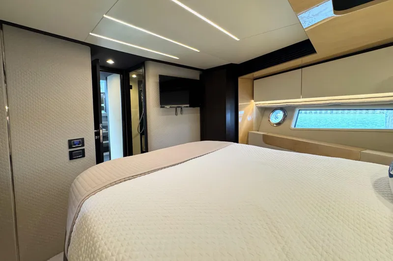 Kiki Yacht Photos Pics Luxurious bedroom interior of 2016 Azimut 66 yacht with modern design and porthole window.