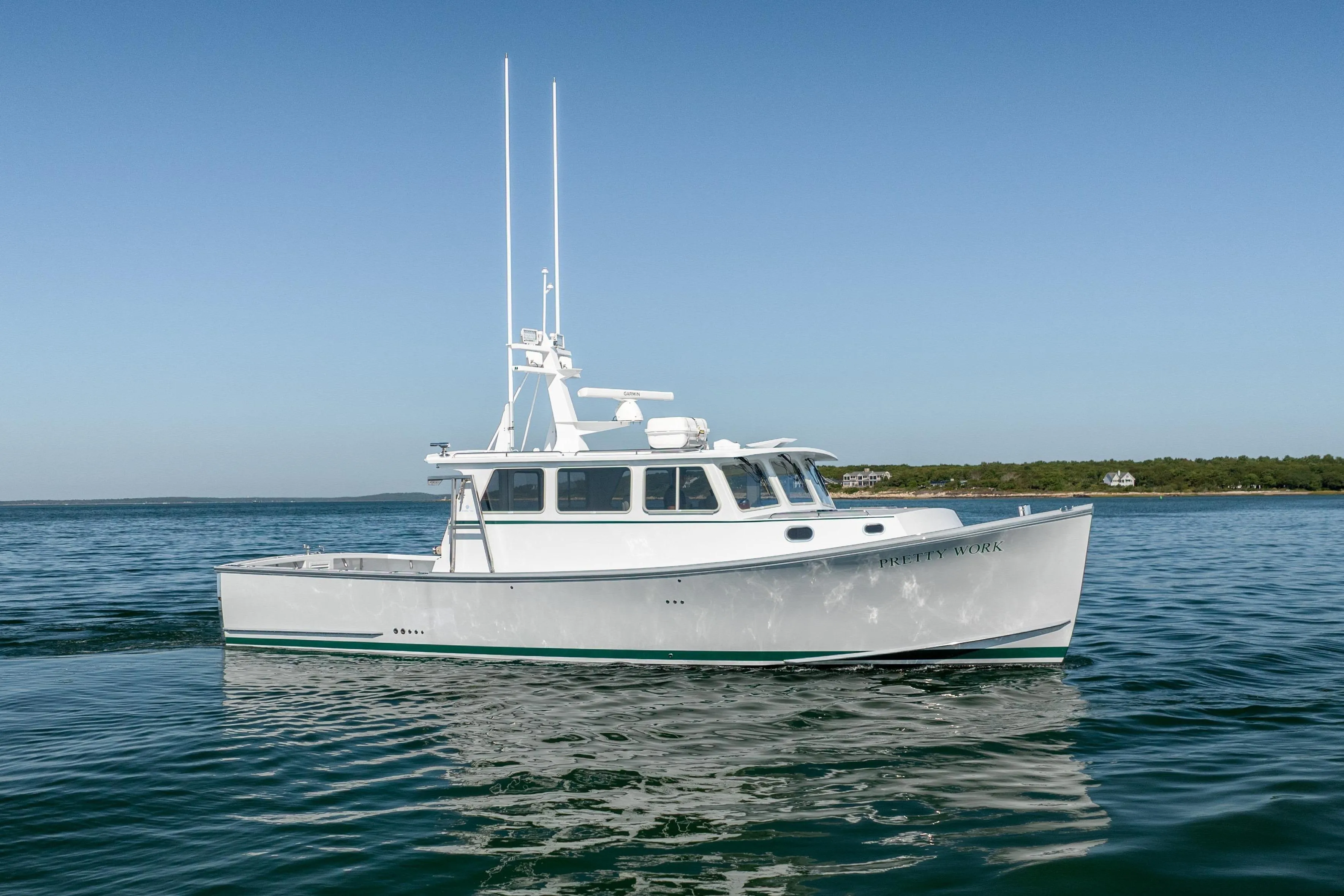 2025 Mussel Ridge 42 boat on calm water under clear blue sky.