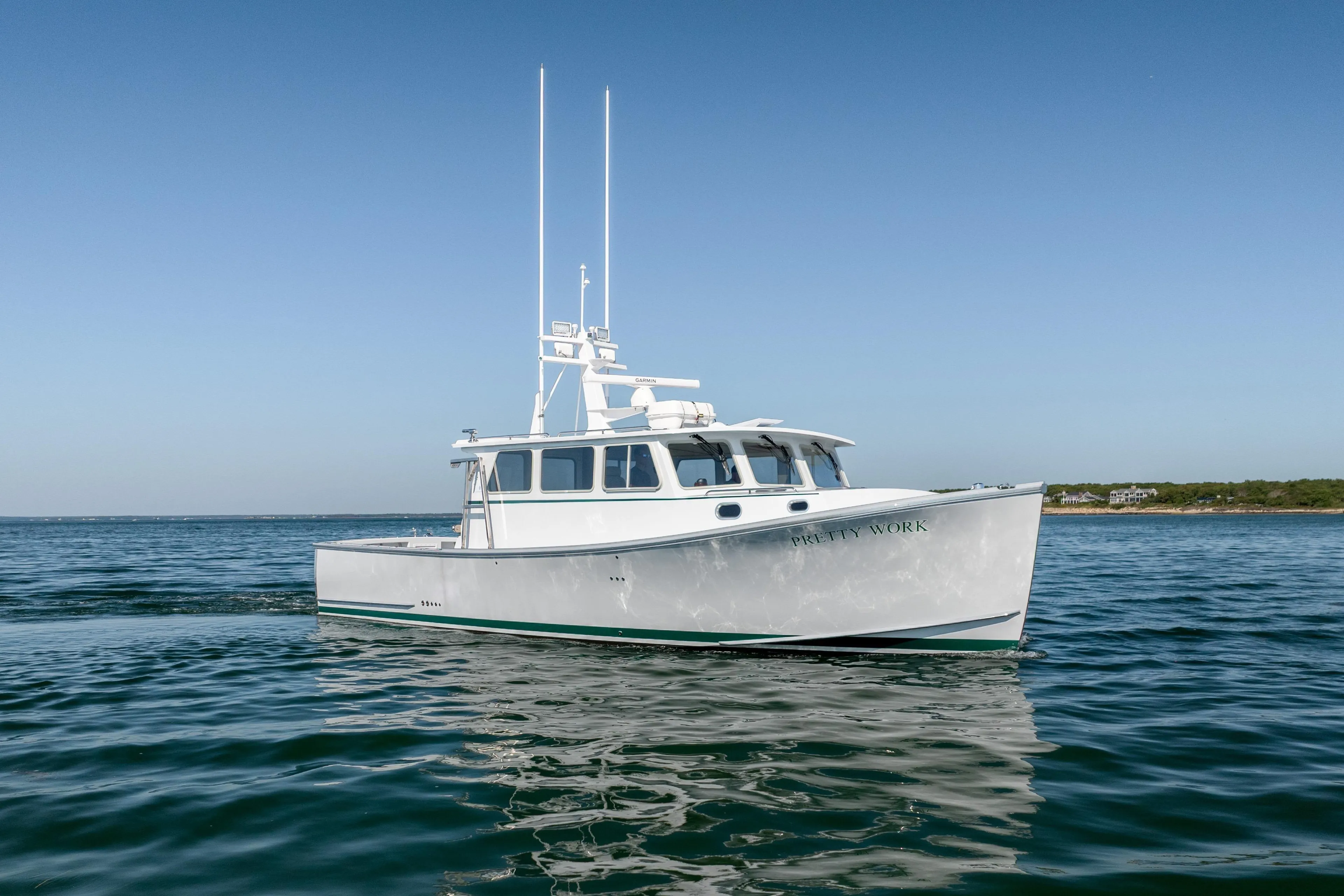 2025 Mussel Ridge 42 boat on calm ocean waters under clear blue sky.