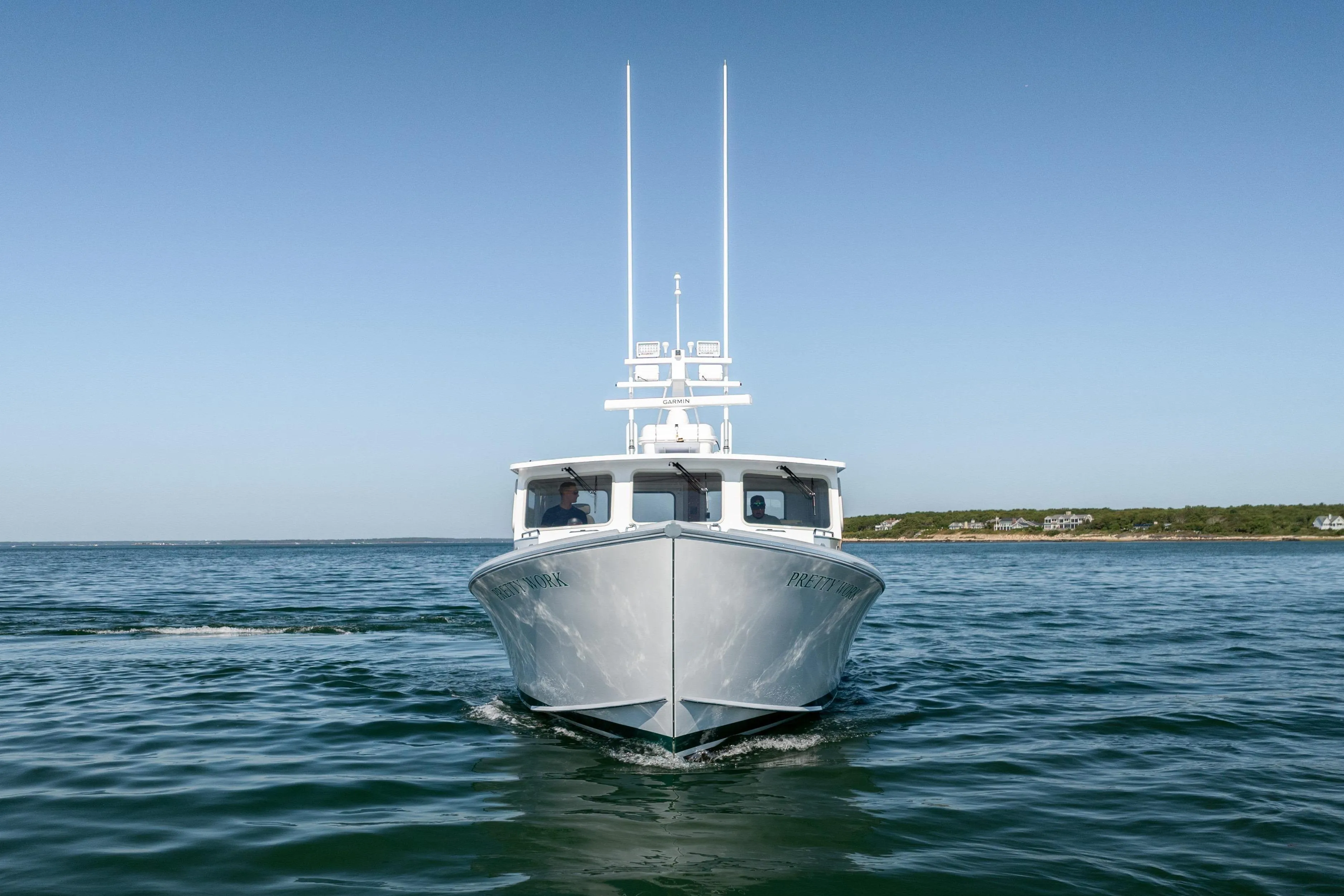 2025 Mussel Ridge 42 boat cruising on calm ocean waters under clear blue sky.