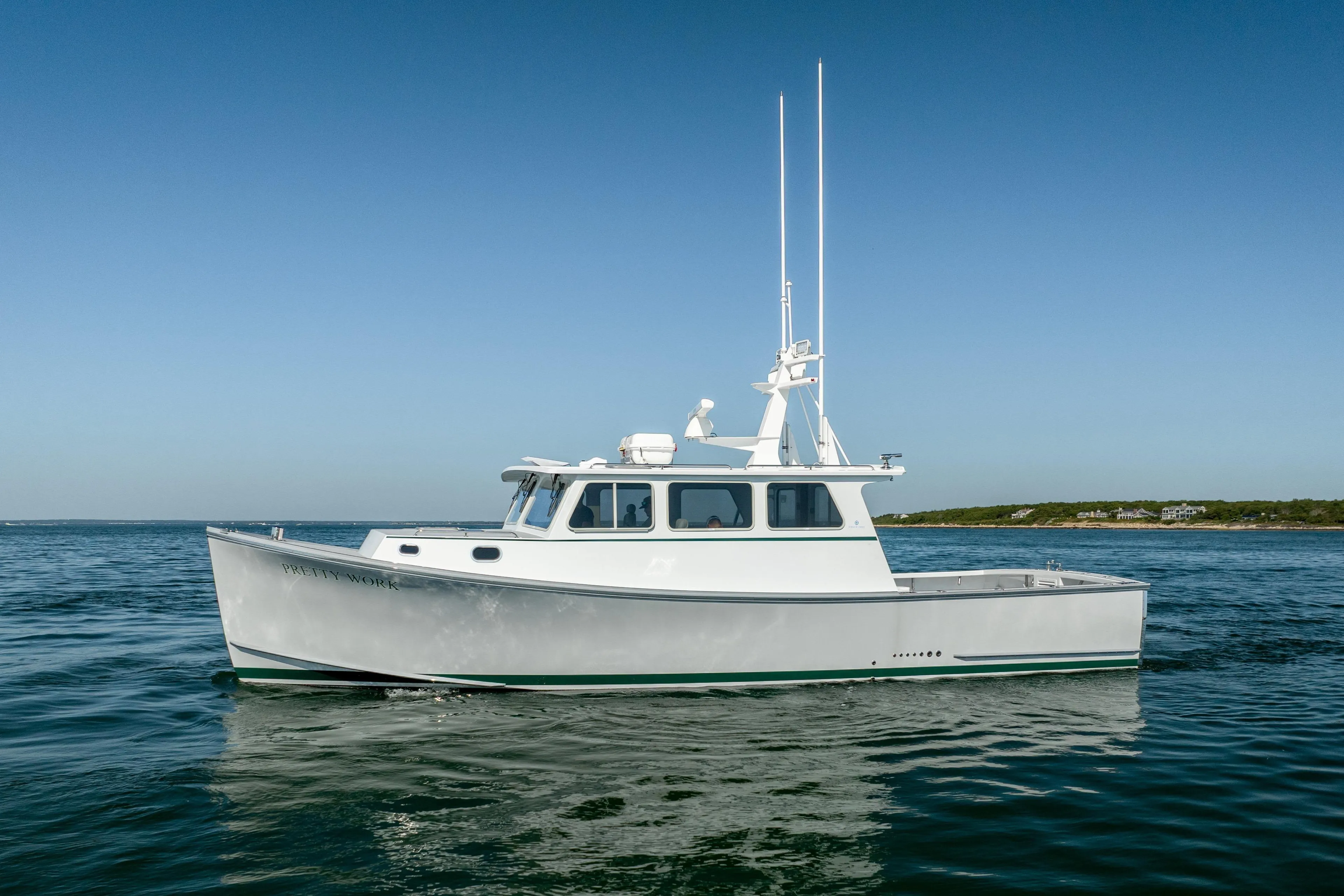 2025 Mussel Ridge 42 boat on calm ocean waters under clear blue sky.