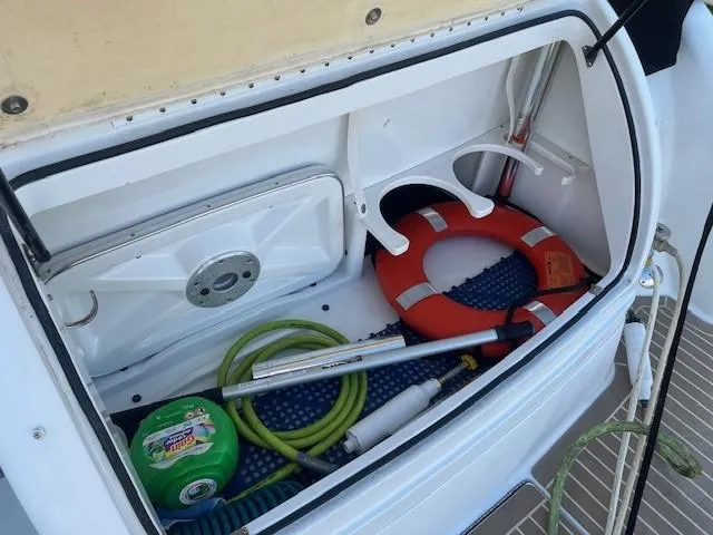  Yacht Photos Pics Storage compartment of 2005 Formula 34PC boat with life preserver and cleaning supplies.