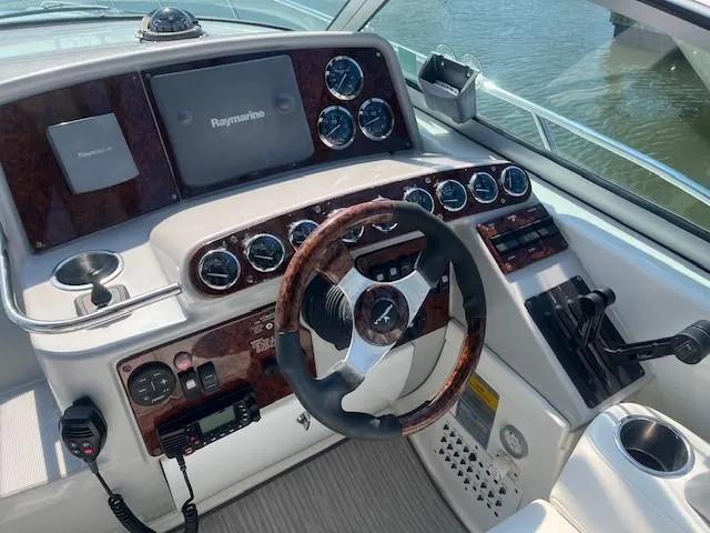  Yacht Photos Pics 2005 Formula 34PC boat dashboard with Raymarine display and wood-accented steering wheel.
