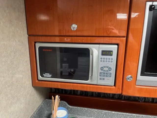  Yacht Photos Pics Built-in microwave in 2005 Formula 34PC boat kitchen, featuring wooden cabinetry.