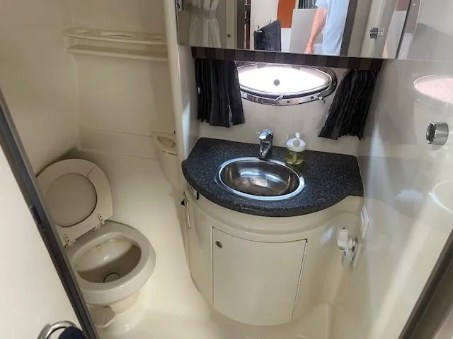  Yacht Photos Pics 2005 Formula 34PC yacht bathroom with sink, toilet, and porthole window.