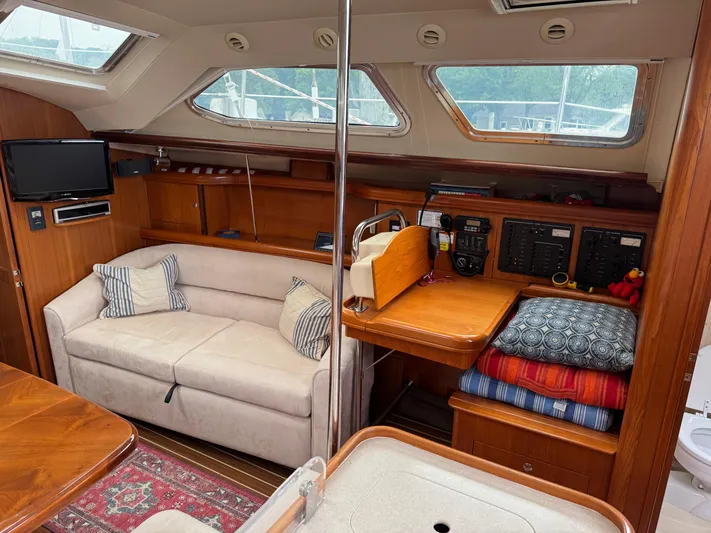 Strider Yacht Photos Pics 2006 Hunter 41 Deck Salon interior with sofa, navigation station, and windows.