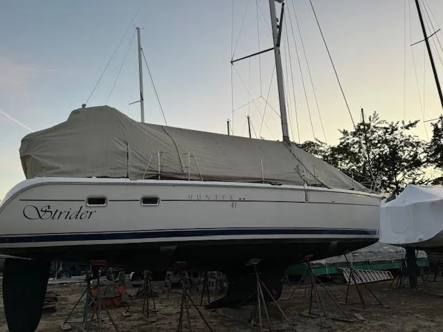 Strider Yacht Photos Pics 2006 Hunter 41 Deck Salon sailboat, covered and elevated on stands, at sunset.