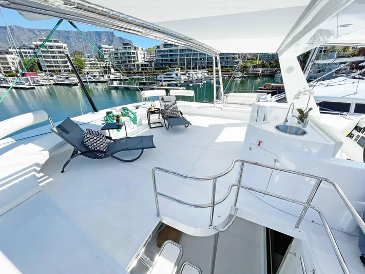 Skye Yacht Photos Pics Luxurious 2023 Mystique Yachts Silhouette 800 deck with lounge chairs and marina view.