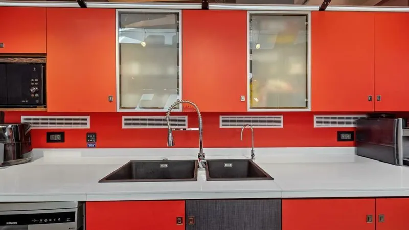 Skye Yacht Photos Pics Modern kitchen on 2023 Mystique Yachts Silhouette 800 with dual sinks and vibrant orange cabinetry.