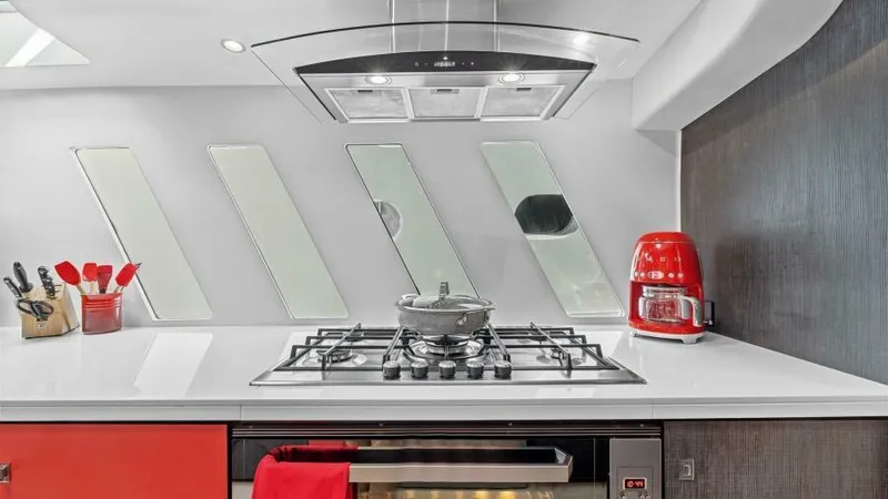 Skye Yacht Photos Pics Modern yacht kitchen with sleek stove, red accents, and unique window design on Mystique Yachts Silhouette 800.
