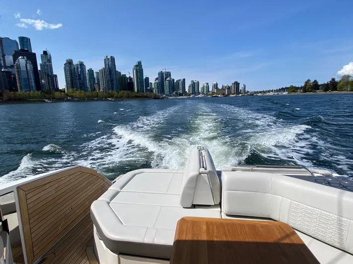 Aquaholic Yacht Photos Pics 2023 Sea Ray SLX 400 cruising with city skyline in the background.