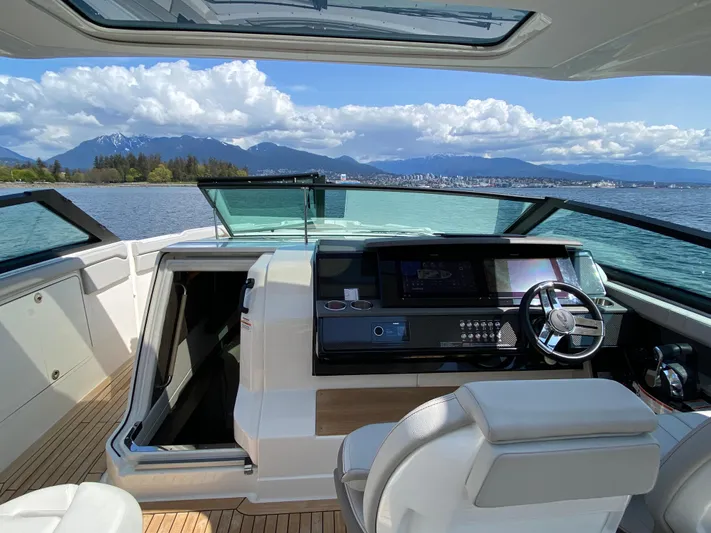 Aquaholic Yacht Photos Pics 2023 Sea Ray SLX 400 boat interior with helm, open water, and mountain view.