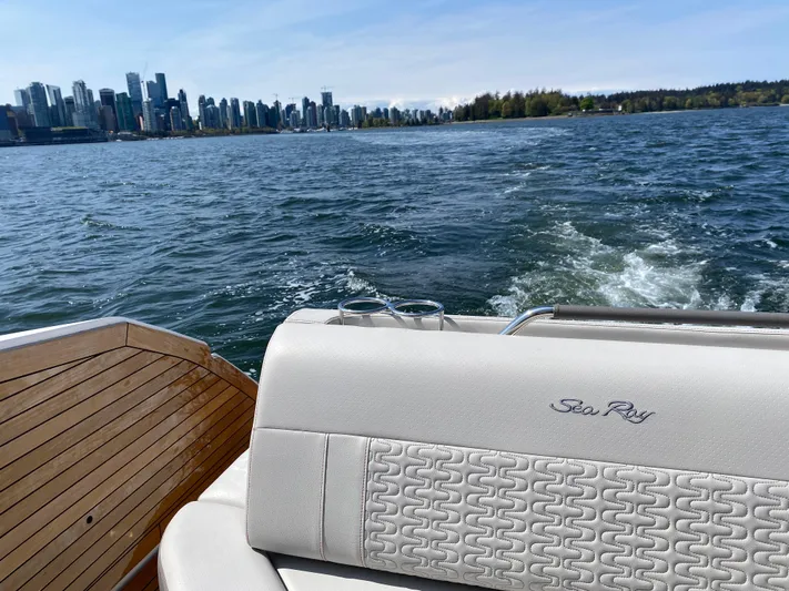 Aquaholic Yacht Photos Pics 2023 Sea Ray SLX 400 boat cruising with city skyline in the background.