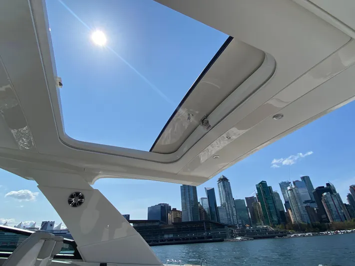 Aquaholic Yacht Photos Pics 2023 Sea Ray SLX 400 yacht with sunroof, city skyline, and sunny sky.