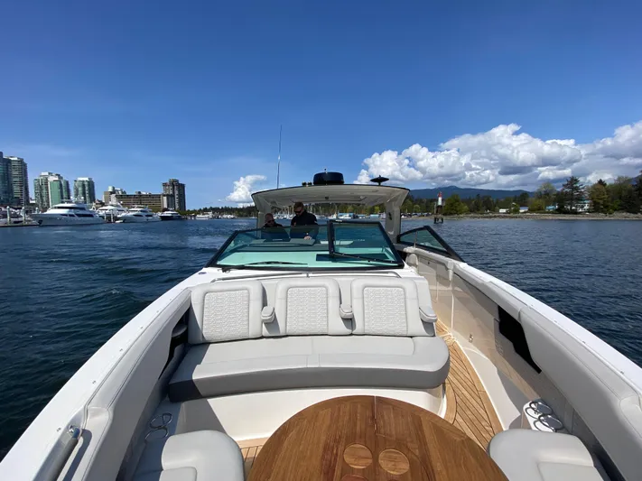 Aquaholic Yacht Photos Pics 2023 Sea Ray SLX 400 boat on water with city skyline and blue sky.