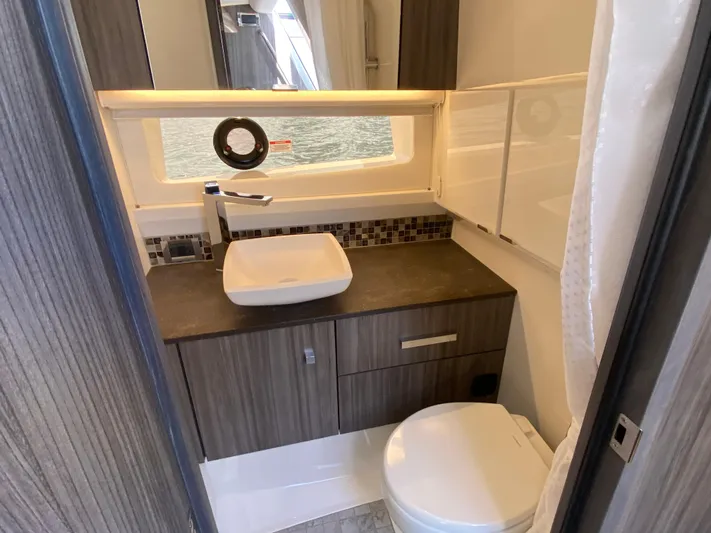 Aquaholic Yacht Photos Pics Modern bathroom in 2023 Sea Ray SLX 400 yacht with sleek fixtures and wood cabinetry.