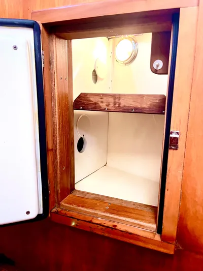 Makasi Yacht Photos Pics Wooden cabinet interior on a 2008 Tartan 4100 yacht, featuring shelves and a porthole.