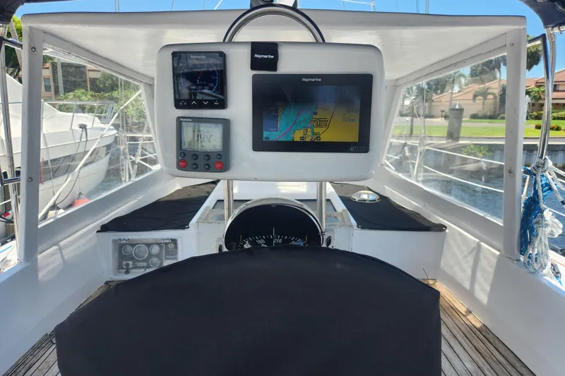 Cookie Monster Too Yacht Photos Pics 1982 Tayana Center Cockpit Cutter Ketch helm with navigation instruments and chart display.