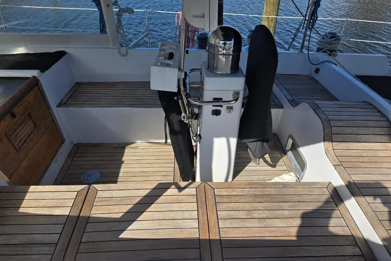 Cookie Monster Too Yacht Photos Pics 1982 Tayana Center Cockpit Cutter Ketch with wooden deck and steering column, docked by water.