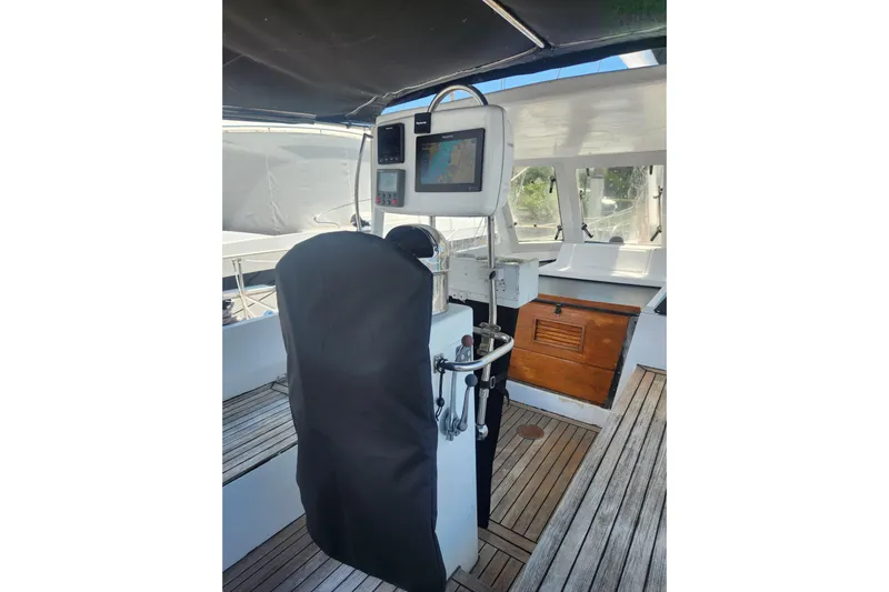 Cookie Monster Too Yacht Photos Pics 1982 Tayana Center Cockpit Cutter Ketch helm with navigation equipment and wooden deck.