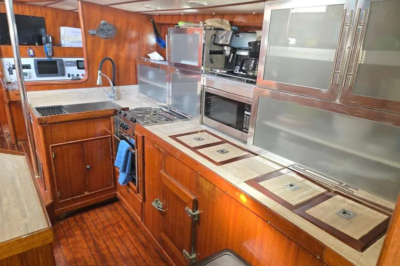 Cookie Monster Too Yacht Photos Pics 1982 Tayana Center Cockpit Cutter Ketch galley with wood cabinetry and modern appliances.