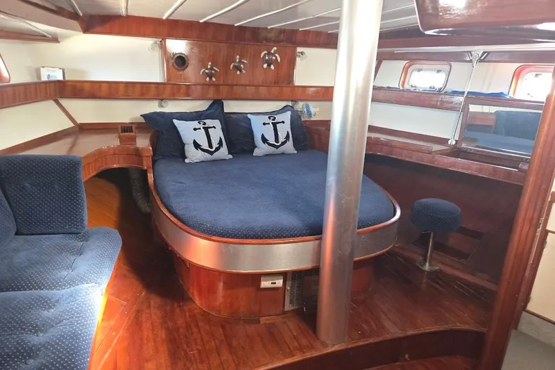 Cookie Monster Too Yacht Photos Pics 1982 Tayana Center Cockpit Cutter Ketch cabin with nautical-themed bedding and polished wood interior.