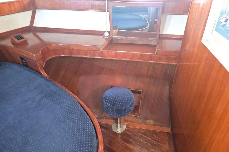 Cookie Monster Too Yacht Photos Pics 1982 Tayana Center Cockpit Cutter Ketch interior with wooden desk and blue cushioned stool.