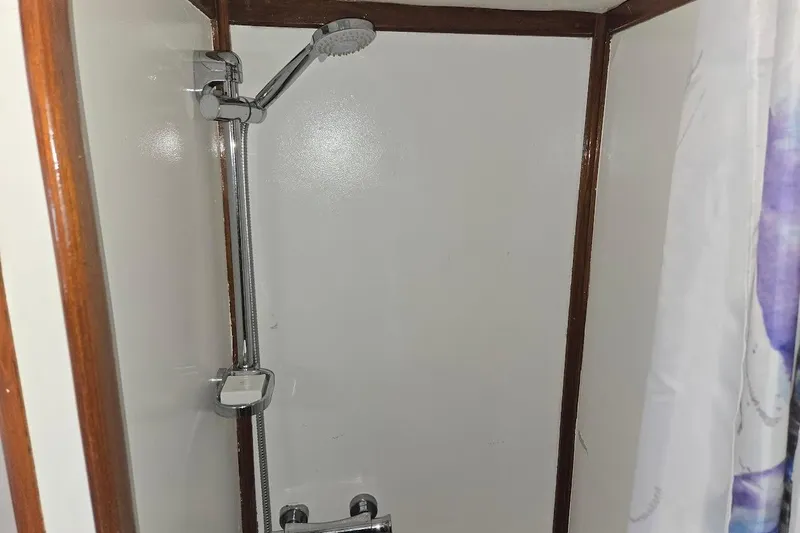 Cookie Monster Too Yacht Photos Pics Shower area in 1982 Tayana Center Cockpit Cutter Ketch, featuring chrome fixtures and wooden trim.